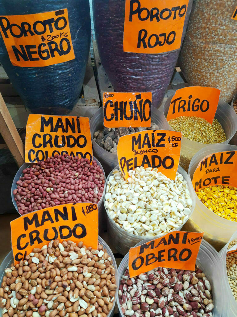 Sacos y tarros con productos regionales de la zona del noroeste argentino, entre ellos poroto negro, poroto rojo, chuño, maíz pelado, mote,, etc